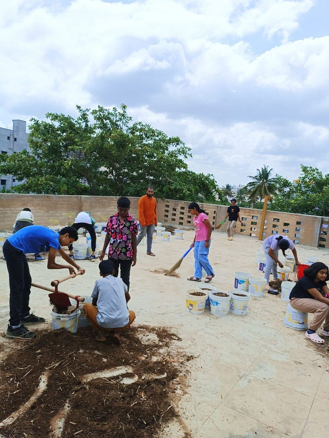 Children carrying buckets of soil to build out a rooftop garden
