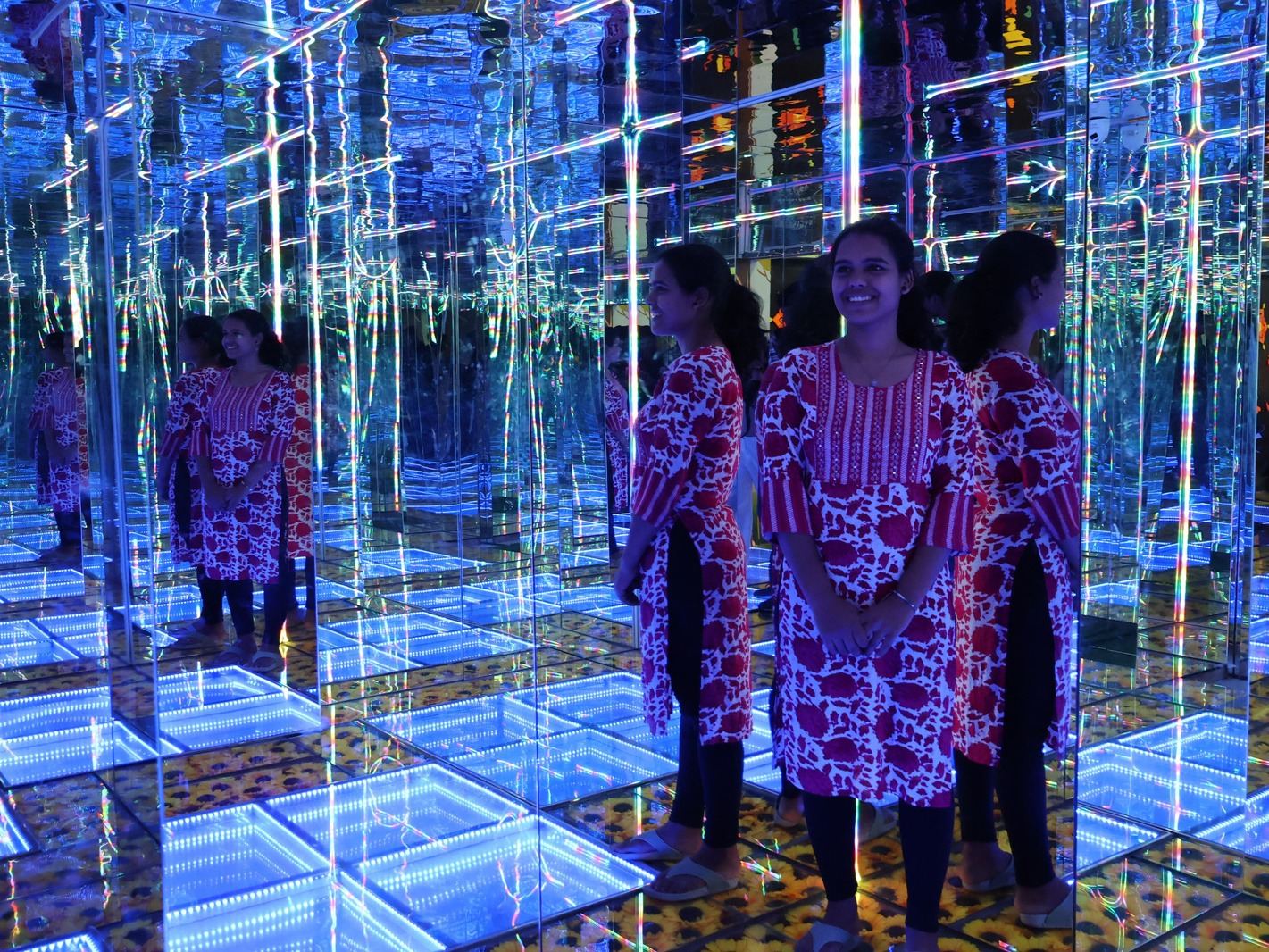 Visitors inside the infinity mirror room at Madlabs, reflected many times over